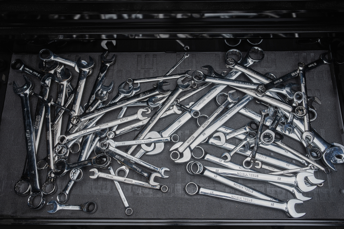 Disordered tool drawer with wrenches scattered loosely — the before state after driving