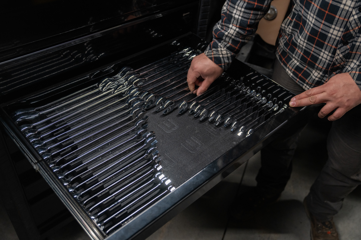 Mechanic indicating the organized wrenches with visible indicator stripes