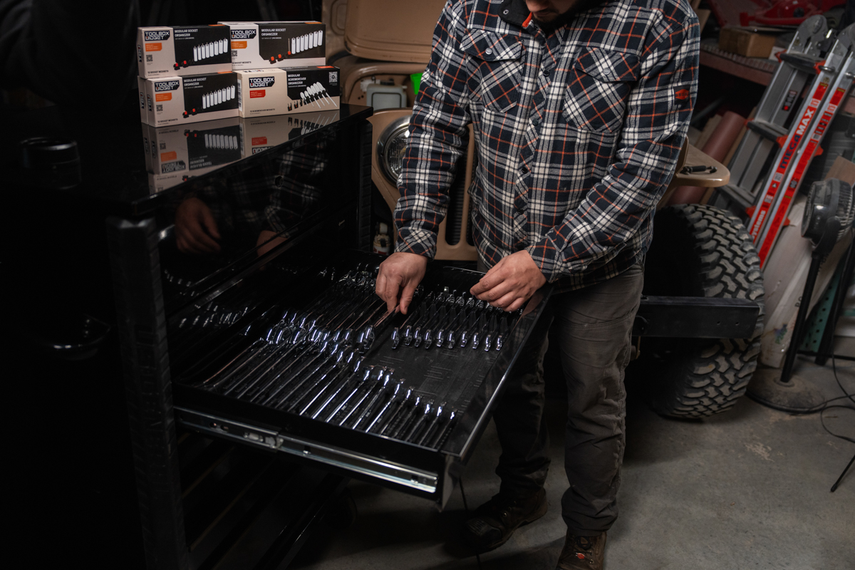 Mechanic organizing tools in a drawer with modular wrench holders