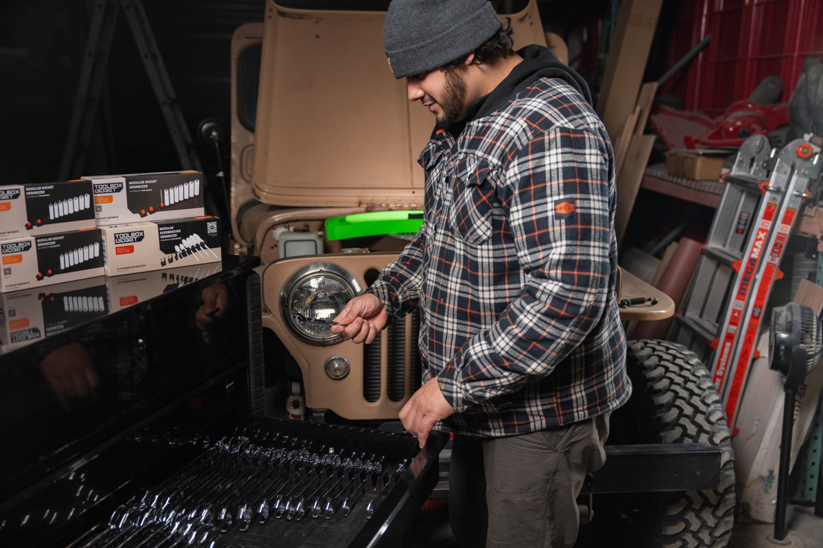 Mechanic selecting a specific wrench from an organized drawer